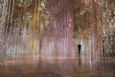 man walking in a room full of flowers